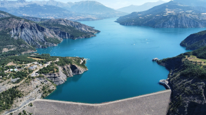 Vue aérienne du lac de Serre-Ponçon avec son barrage et les montagnes environnantes.