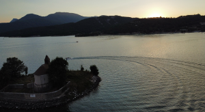 Vue d'un lac avec des montagnes en arrière-plan au coucher du soleil.