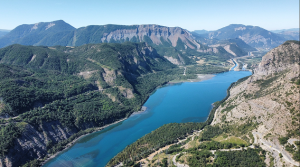 Vue aérienne d'une rivière serpentant dans une vallée montagneuse.